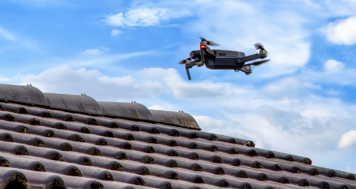 Un dron de Mighty Dog Roofing inspeccionando un tejado de tejas de arcilla