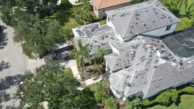 Techador quitando tejas viejas durante un reemplazo de techo en Bradenton.