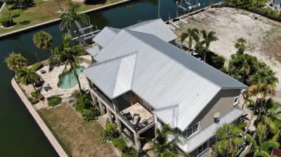 Nuevo techo metálico instalado en una vivienda de Florida, con líneas limpias y materiales resistentes a huracanes en un barrio residencial.