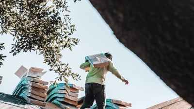 hombre cargando contrapiso en un tejado