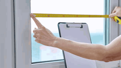 Contratista de ventanas midiendo el marco de una ventana