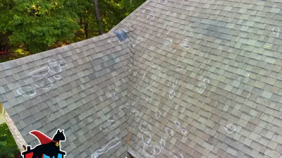 Close-up of hail damage inspection on asphalt shingle roof in Centerton with chalk circles marking impact points and a hail test square used to document storm damage.
