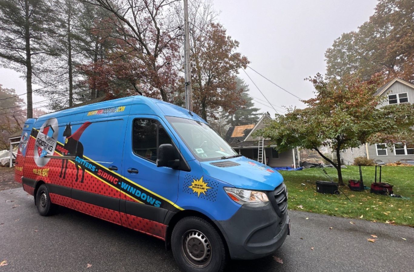 Un técnico Mighty Dog Roofing preparación de bajantes en Tewksbury, MA para dirigir el agua de lluvia de forma segura fuera de la casa.