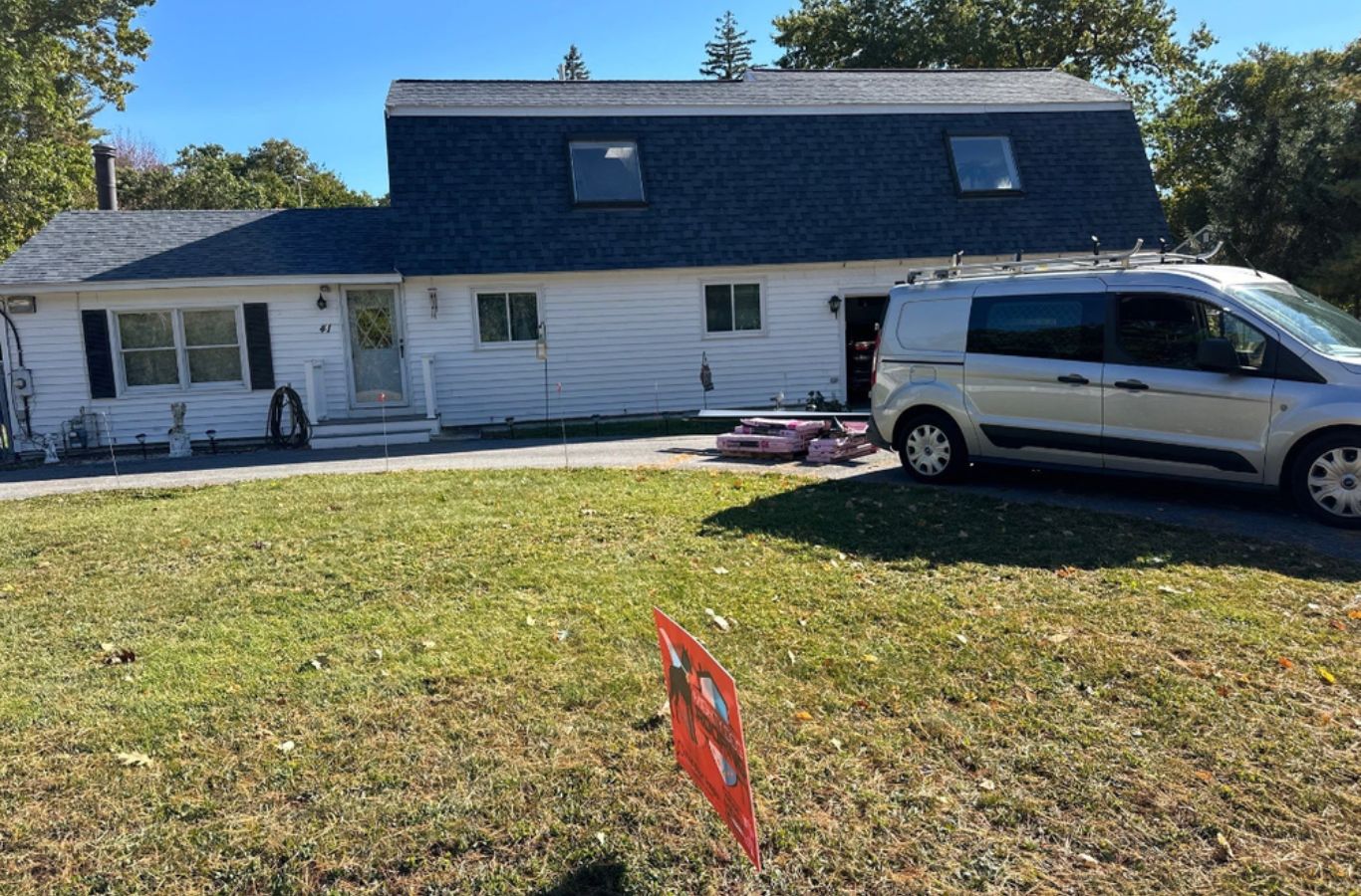 Un miembro del equipo de Mighty Dog Roofing of Greater Middlesex County instalando paneles de revestimiento en Belmont, MA, asegurando un ajuste personalizado y un rendimiento duradero.