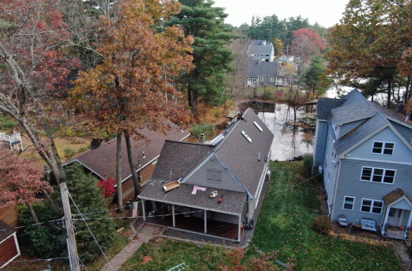 Un instalador de Mighty Dog Roofing of Greater Middlesex County trabajando en el revestimiento en Belmont, MA con herramientas de precisión, materiales duraderos, y la técnica de expertos.