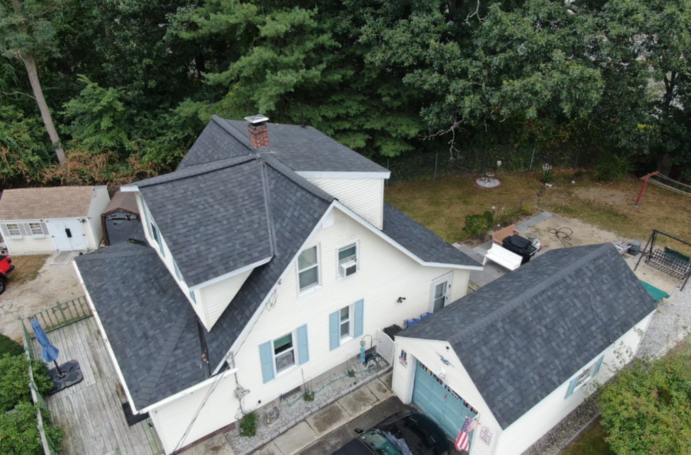 Un miembro del equipo de Mighty Dog Roofing of Greater Middlesex County instalando revestimiento en Carlisle, MA utilizando materiales de primera calidad y mano de obra experta.