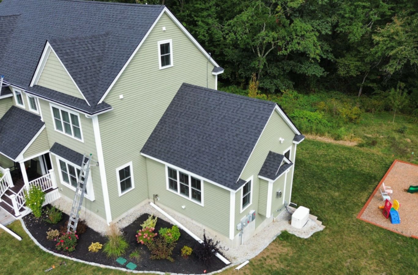 Un miembro del equipo de Mighty Dog Roofing of Greater Middlesex County instalando revestimiento en Dunstable, MA utilizando materiales de alto rendimiento y herramientas profesionales.