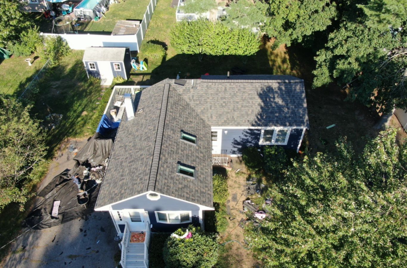 Un técnico de Mighty Dog Roofing instalación de revestimiento duradero en Winchester, MA con herramientas de precisión y mano de obra experta.