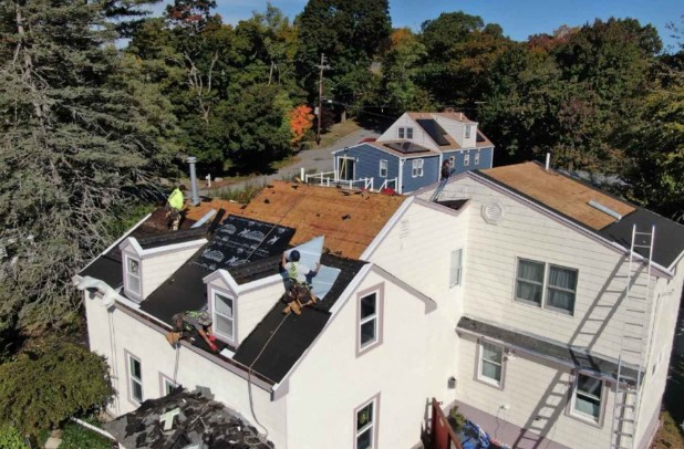 Techador de Mighty Dog Roofing evaluando un tejado en Waltham, MA.