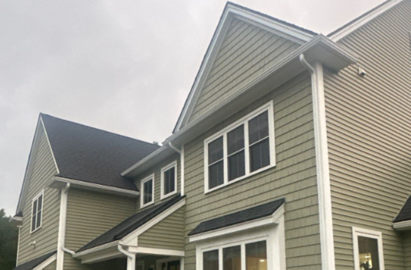 Un profesional de Mighty Dog Roofing of Greater Middlesex County completando la instalación de revestimiento en Belmont, MA, mostrando artesanía de calidad y experiencia local. Siding Company cerca de mí.