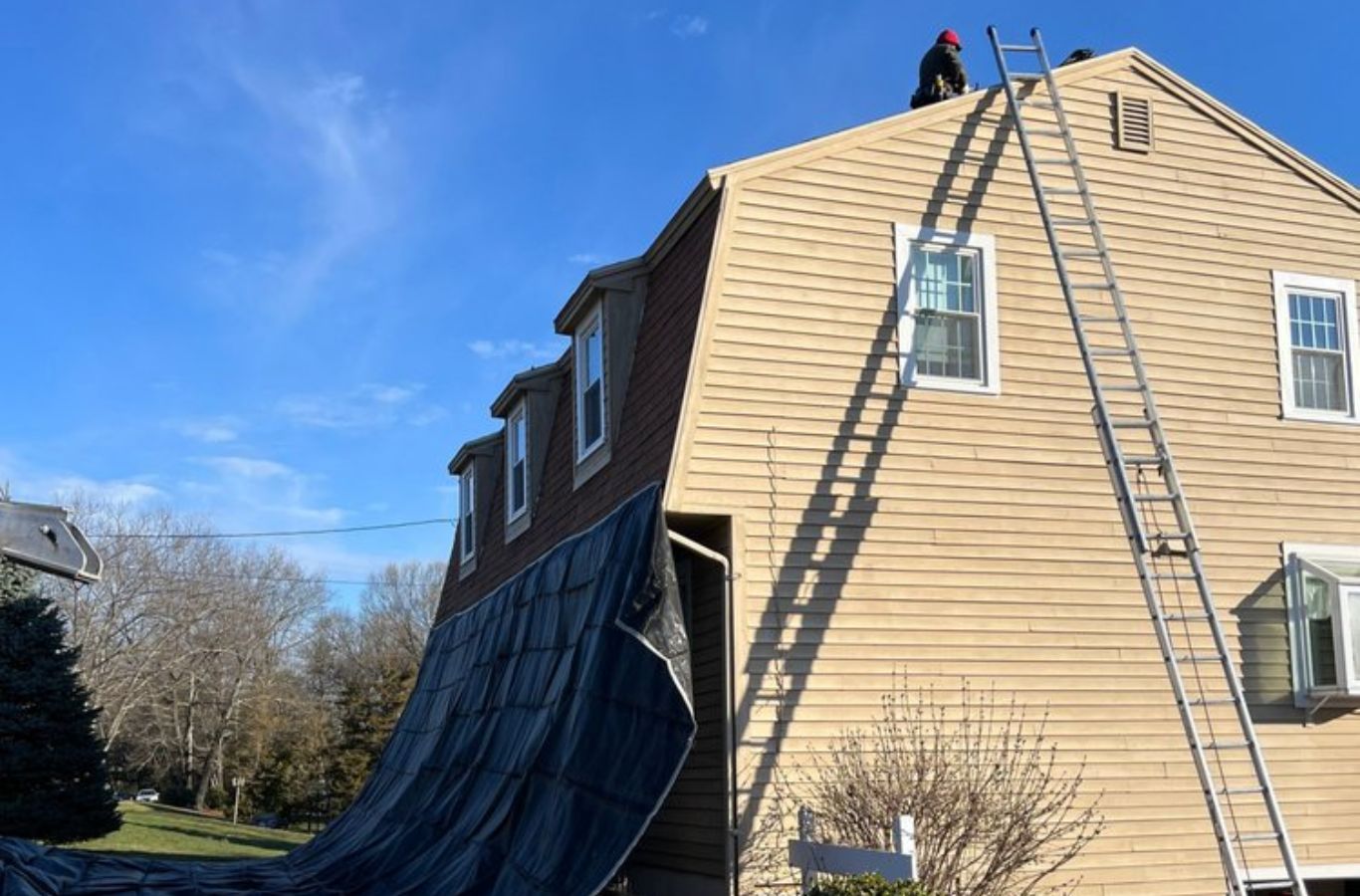 Un equipo de Mighty Dog Roofing terminando un proyecto de techo en Dracut, MA, destacando resultados fiables y de primera clase de atención local de techado.