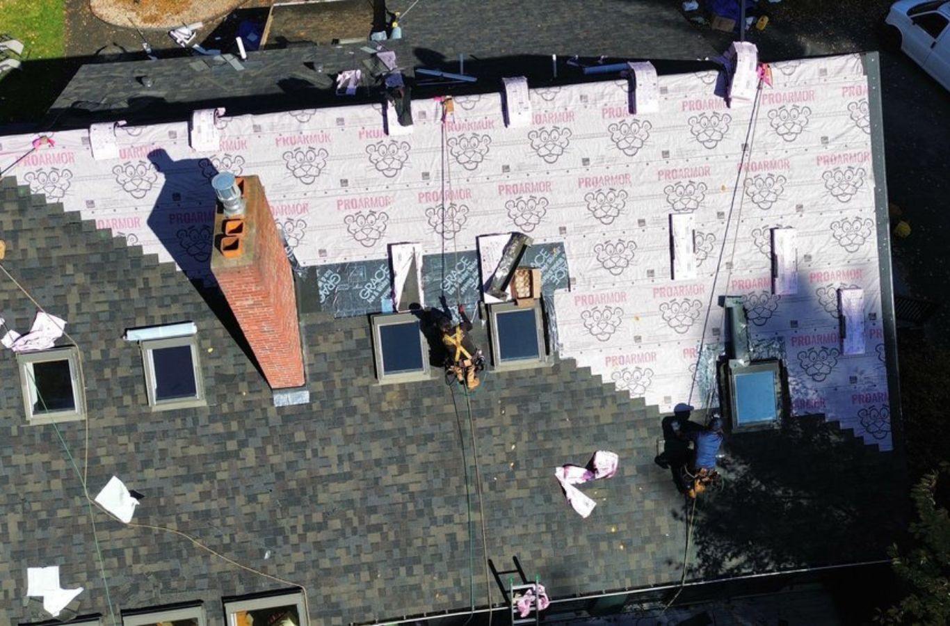 Techadores de Mighty Dog Roofing añadiendo toques finales en un nuevo techo en Lexington, MA, lo que refleja el valor de la contratación de profesionales locales de confianza.