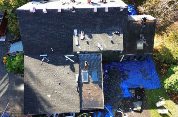 Técnico de tejados realizando una instalación detallada de tejados en Dunstable, MA. Roofing Company cerca de mí.