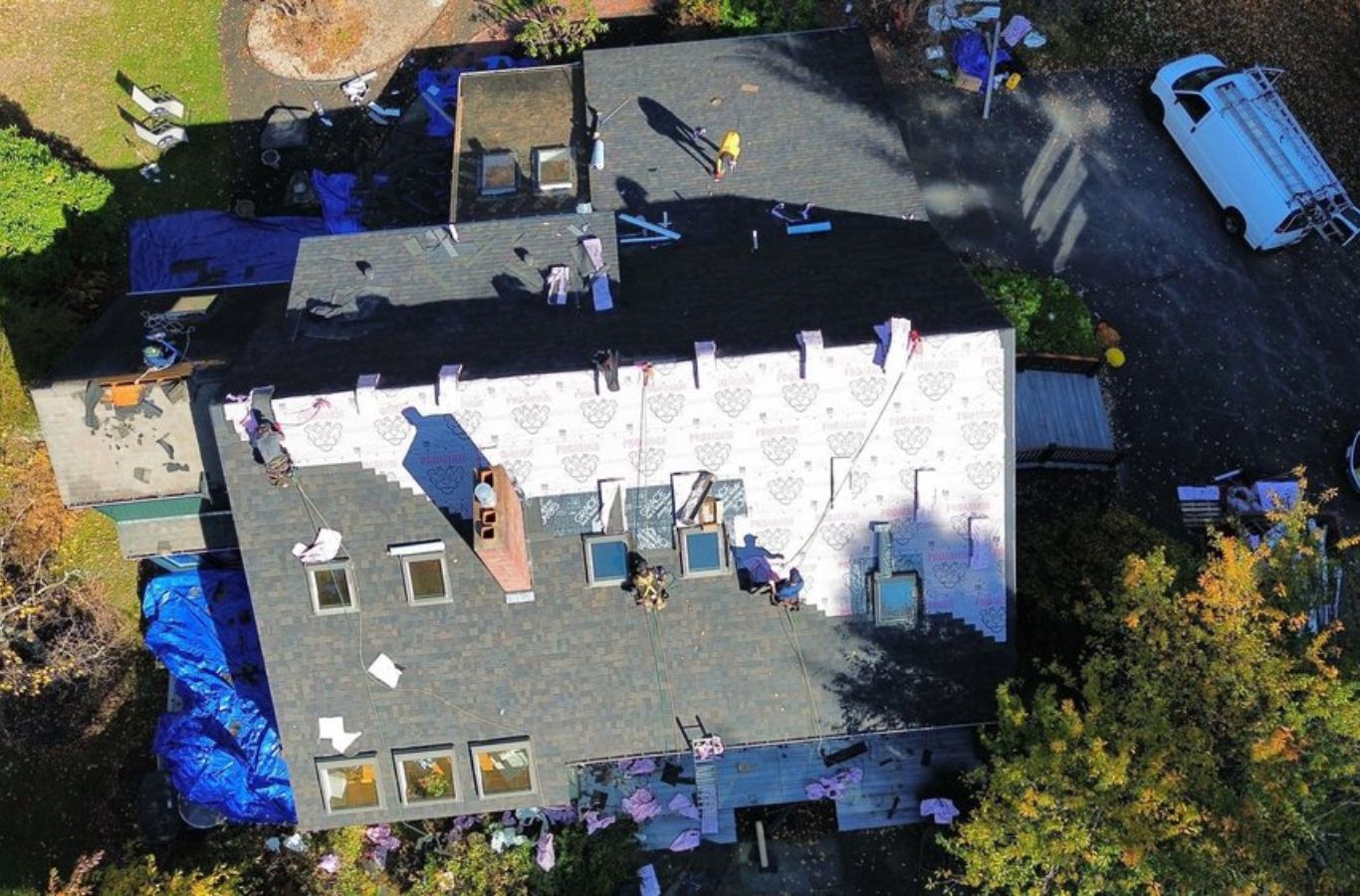 Una toma aérea de Mighty Dog Roofing de Greater Middlesex County realizando un reemplazo de techo en Acton, MA, mostrando profesionalismo y cuidado en cada trabajo.