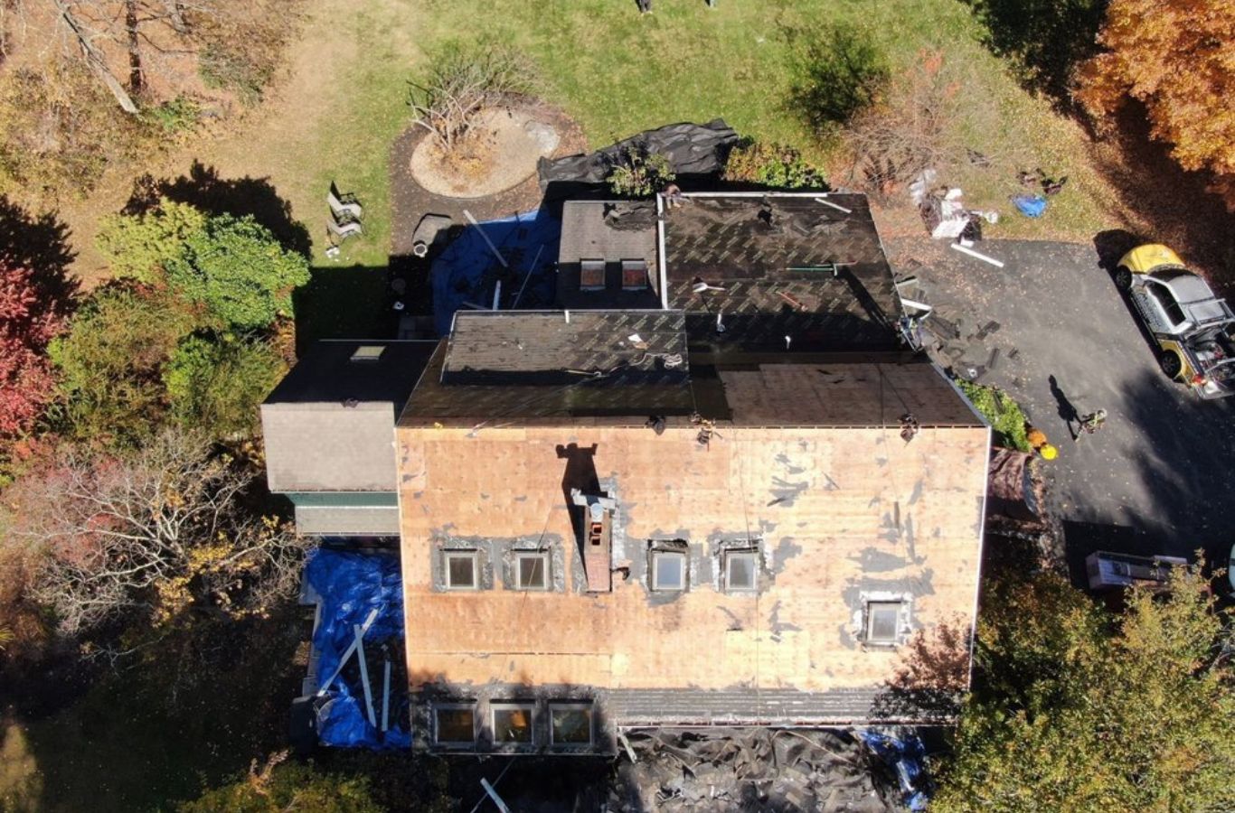 Mighty Dog Roofing de Greater Middlesex County tripulación de trabajo de manera eficiente en una azotea empinada en Acton, MA. Roofing Company cerca de mí.