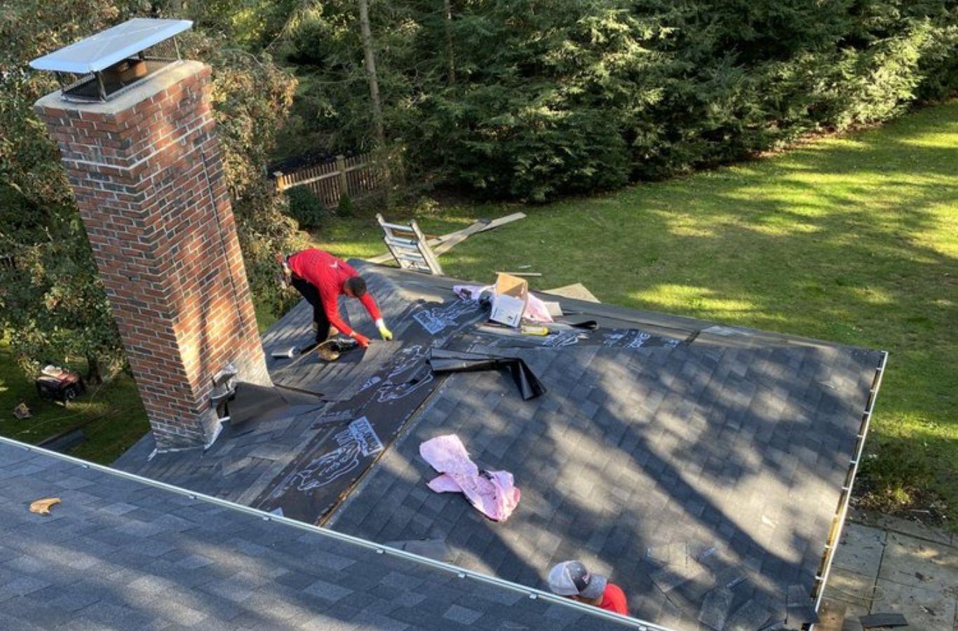 Los técnicos de Mighty Dog Roofing finalizando un proyecto residencial en Lowell, MA, empresa de techado cerca de mí.