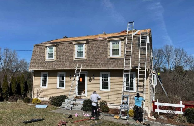 Especialista en tejados de Mighty Dog Roofing trabajando en un tejado de Wilmington, MA. Roofing Company cerca de mí.