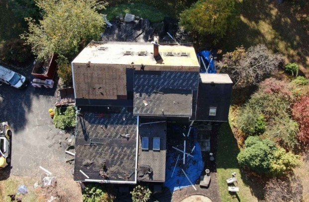 Un techador profesional trabajando en una propiedad residencial en Harvard, MA, asegurando una instalación resistente a la intemperie.