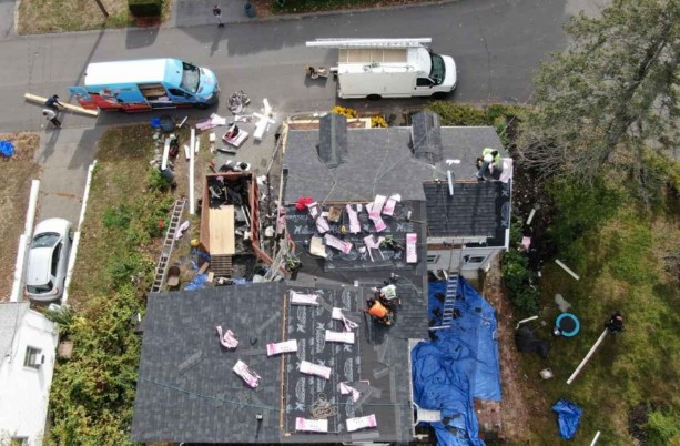 Techador de Mighty Dog Roofing instalando tejas en una casa de Maynard, MA.