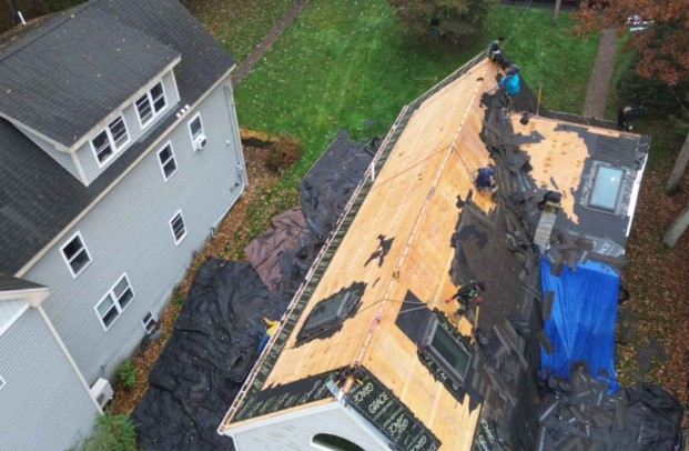 Instalación de techos por Mighty Dog Roofing en un día soleado en Stow, MA. Roofing Company cerca de mí.