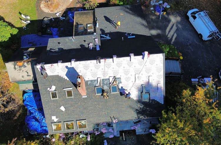 Una empresa de techado en Tewksbury, MA, de Mighty Dog Roofing manejar el trabajo del techo con precisión y equipo de seguridad en el lugar.