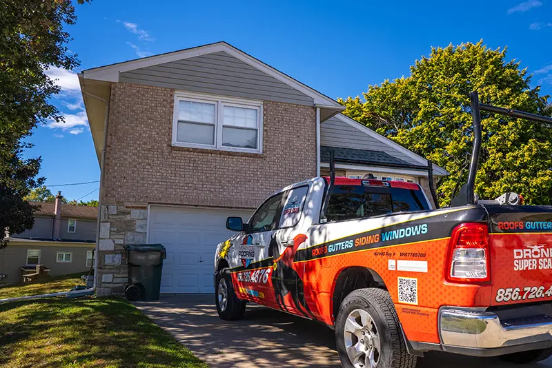 El camión de Mighty Dog Roofing aparcado delante de la casa que necesita una inspección del tejado.