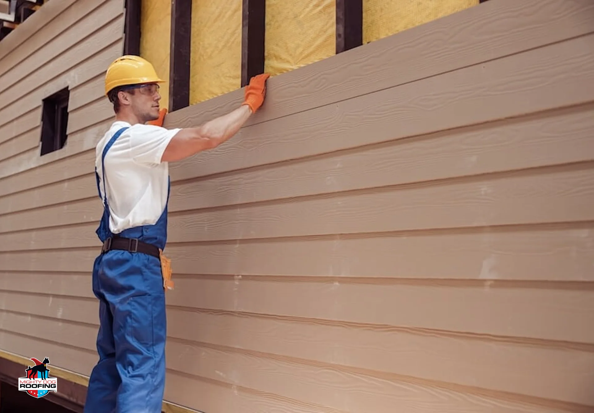Siding contractor inspecting home exterior